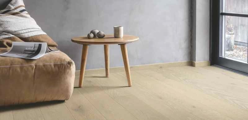 Lys stue med beige sofa og parkett på gulvet